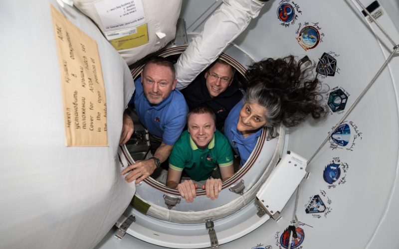 NASA's SpaceX Crew-9 members pose together for portrait inside the vestibule between the International Space Station and the SpaceX Dragon crew spacecraft. Clockwise from left, are NASA astronauts Butch Wimore, Nick Hague, and Suni Williams, and Roscosmos cosmonaut Aleksandr Gorbunov